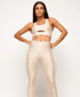 Top deportivo color beige, con textura acanalada y corte con abertura en el centro del pecho.