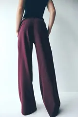 Pantalón de vestir de pierna ancha, color bordó oscuro, con finas rayas verticales en tono similar. Presenta cintura clásica con cierre de botón y bolsillos al bies.