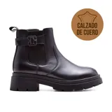 Bota Chelsea de cuero negro con elásticos laterales, hebilla decorativa y suela track.