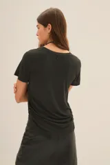 Remera negra de manga corta confeccionada en viscosa, con estampa frontal de una baterista y apliques de lentejuelas y mostacillas.