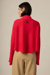 Sweater de tejido de punto en color rojo, con cuello alto y mangas largas acampanadas. Presenta un diseño de corte recto y holgado.