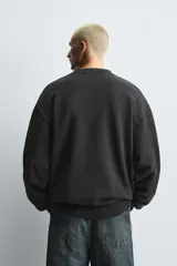 Sudadera de cuello redondo y manga larga con corte relajado. Presenta un acabado con efecto lavado y detalles en rib en puños y ruedo.