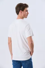 Remera azul marino de manga corta con cuello redondo, confeccionada en mezcla de algodón y poliéster. Presenta un diseño en el frente que combina estampa y bordado con la leyenda "Legacy Brand 1972" en tonos rosado, verde y marrón.