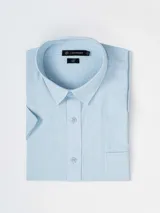 Camisa de manga corta color celeste con efecto lino, cuello camisero, cierre frontal con botones y un bolsillo ojal en el pecho.