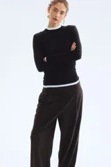 Pantalón amplio color negro, de corte holgado con pinzas, cierre con botón y corchetes ocultos, bolsillos laterales y piernas con pliegues adelante y atrás.