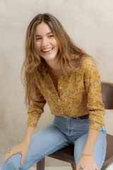 Camisa amarilla con estampado de flores pequeñas en tonos rosados y blancos, de corte clásico y manga larga.