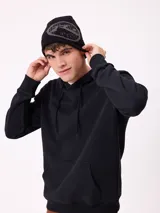 Gorro tipo beanie de punto color negro con diseño gráfico circular en gris en la parte frontal.