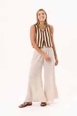 Pantalón palazzo beige de tiro alto, con cintura elástica fruncida y diseño amplio de pernera ancha.