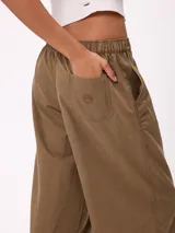 Pantalon de gabardina de corte recto y pata ancha, con cintura elástica y etiqueta decorativa en el frente.