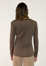 Remera de manga larga en color blanco, con cuello redondo y detalle de costura en el borde del escote. Confeccionada en tejido de algodón, presenta un corte recto y básico.