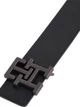 Cinturón reversible de cuero con hebilla metálica que presenta el monograma TH. El diseño cuenta con un lado de acabado liso y otro con acabado granulado.