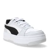 Championes Puma Rebound Femme Low de estilo urbano con plataforma. Presentan una capellada de cuero sintético blanco con la icónica franja lateral de Puma en color negro y detalles en gris claro. Cuentan con cierre de cordones, cuello acolchado y suela de goma robusta.