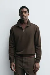 Sudadera regular fit de color marrón, con cuello alto y cierre frontal de cremallera corta, manga larga y puños y dobladillo en rib.