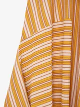 Vestido largo de viscosa con diseño asimétrico, tirantes finos, escote en V y estampado de líneas diagonales amarillas sobre fondo rosado.