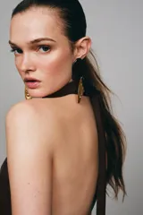 Vestido corto de cuello halter con espalda descubierta, diseño con frunces en el cuerpo y bajo con lentejuelas brillantes. Cuenta con forro interior y cierre trasero con cremallera oculta.