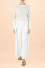 Sweater de punto color blanco con textura en relieve, cuello redondo y mangas largas abullonadas con puños ajustados.