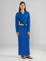 Camisa negra de manga larga con lazo en la cintura y botones nacarados. Confeccionada en 100% algodón y detalle de Polonio en cobre.