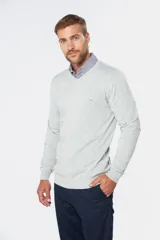 Suéter de tejido fino color azul marino, con cuello en V y manga larga. Presenta un pequeño logo bordado en el pecho.