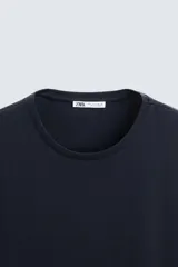 Camiseta slim fit de manga corta y cuello redondo, confeccionada en tejido de algodón con elasticidad.