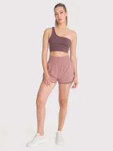 Short deportivo de tiro alto con calza incorporada, pretina ancha elástica y bolsillo lateral. Diseño de doble capa con ajuste regular.