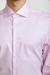 Camisa de vestir blanca de corte clásico, con cuello rígido, cierre frontal de botones y mangas largas con puños abotonados.