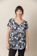 Remera blanca con estampado de hojas de palmera en negro, escote en V y mangas cortas.