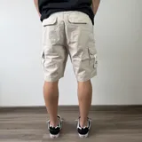 Bermuda cargo de gabardina color gris oscuro, con múltiples bolsillos laterales con solapa y cierre de botones.
