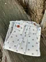 Bombacha de campo de lino color beige con estampado de pequeñas flores oscuras. Presenta pinzas frontales, cierre de botones en la cintura y pasacintos.
