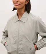 Campera deportiva de corte oversized, confeccionada en poliamida con tecnología dry. Presenta cuello camisero estructurado, cierre frontal con cremallera, bolsillos laterales, puños elásticos y ruedo con ajuste elástico.