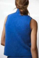 Chaleco de punto rojo con cuello subido y manga sisa.