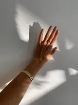 Anillo abierto de diseño orgánico con textura irregular y acabado brillante, realizado artesanalmente en metal.