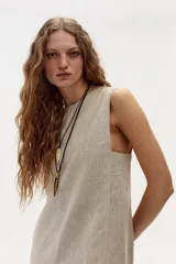 Vestido midi color beige de lino, corte recto y sin mangas.