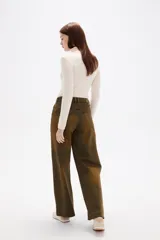 Pantalon de jean de corte ancho y tiro medio, con efecto de lavado desgastado en tonos marrones y verdosos. Cuenta con bolsillos laterales y traseros.
