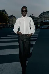 Camisa corta blanca de popelín con cuello solapa decorado con abalorios joya, manga larga y cierre frontal de botones.