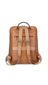 Mochila de diseño rectangular con textura símil cuero efecto cocodrilo en color tostado. Cuenta con un bolsillo frontal con cierre, compartimento principal con doble cierre, correas ajustables y manija superior. Incluye detalles metálicos y placa con logo de la marca.