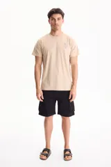 Remera beige de manga corta con pequeño estampado azul en el pecho de palmeras y la inscripción "Hello Beach".