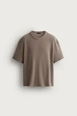 Remera de punto color marrón, de corte relaxed fit con cuello redondo y mangas cortas, con efecto lavado.