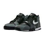 Championes Nike Air Trainer 1 de corte medio, con diseño en combinación de colores negro y gris. Presenta una correa ajustable sobre el empeine con el logo de la marca, el icónico swoosh lateral en color blanco y suela de goma con entresuela blanca.