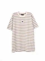 Remera de corte holgado con diseño de rayas horizontales en color beige y blanco, cuello redondo y parche pequeño con logo en el centro del pecho.