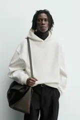 Sudadera tipo hoodie de corte boxy fit, confeccionada en tejido doble compacto de mezcla de algodón. Presenta cuello con capucha, manga larga y acabados en el mismo tejido.