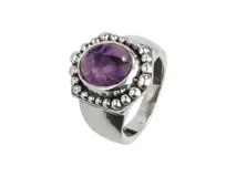 Anillo de plata 925 con una piedra amatista redonda engarzada en un bisel con borde de pequeñas esferas.