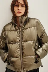 Campera puffer de cuello alto con cierre frontal, acabado metalizado y bolsillos laterales con cierre.