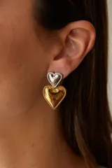 Aros colgantes dorados con forma de corazón doble.