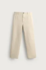 Pantalón chino regular fit de color beige, confeccionado en tejido de algodón. Cuenta con bolsillos frontales, detalle de bolsillo cerillero, bolsillos traseros de doble vivo y cierre frontal con cremallera y botón.