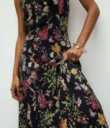 Vestido midi negro con estampado floral, tirantes finos, escote cuadrado y corte evasé en tejido de chiffon.