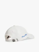 Gorra de béisbol blanca de seis paneles, confeccionada en algodón, con bordados en hilo azul de la marca Tommy Hilfiger en la parte frontal y lateral.