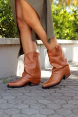 Bota de cuero color marrón, de caña media, con punta cuadrada y taco bajo.