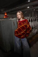 Sweater de lana tejido y bordado a mano en Uruguay, de calce holgado con cuello a la base y puños. Diseño con rombos en tonos rojo, negro, amarillo y marrón.