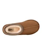 Zuecos UGG modelo Tasman II, color tostado, confeccionados en gamuza con forro interior de piel de oveja. Presentan un ribete trenzado característico en el cuello y suela de goma resistente.