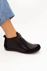 Zapato bajo de cuero color beige con refuerzos en gamuza en la puntera y el talón. Cuenta con doble cierre lateral diagonal, presilla trasera y suela de goma con relieve.